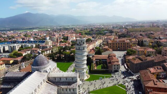 Famous Leaning Tower of Pisa by drone showcasing the houses of Pisa city around it on a sunny day