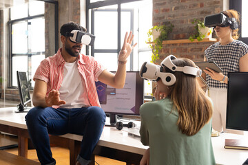 Diverse team in VR headsets explores digital space in a modern office