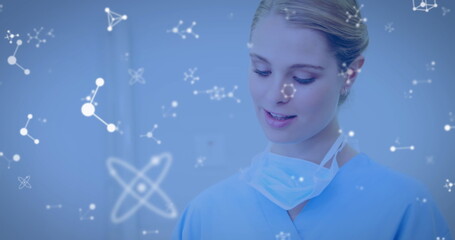 Image of molecules flowing over female doctor with face mask using digital tablet