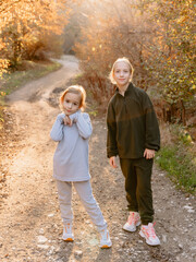Cute girls posing outdoor. Kids sisters happy and looking at camera