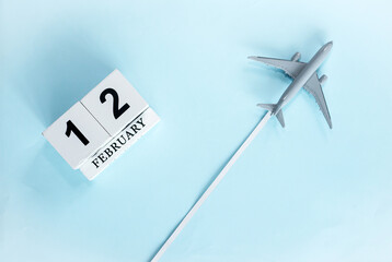 February calendar with number  12. Top view of calendar with flying passenger plane. Scheduler....
