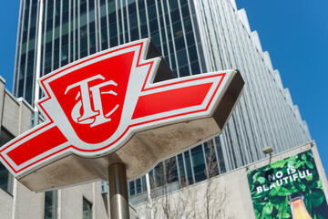 Fototapeta premium skyward glance at TTC logo sign and building at Eglinton Station (Yonge Street entrance) in Toronto, Canada