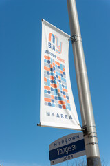 Fototapeta premium Midtown BIA banner on a blue sky located on Yonge Street in Toronto, Canada