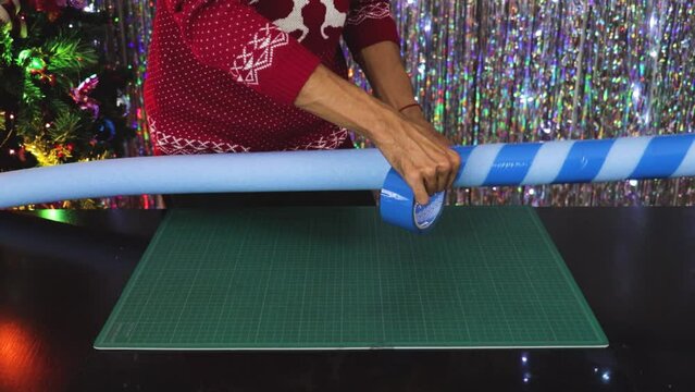 Handmade Christmas decorations, wrapping up blue tape on cany cane