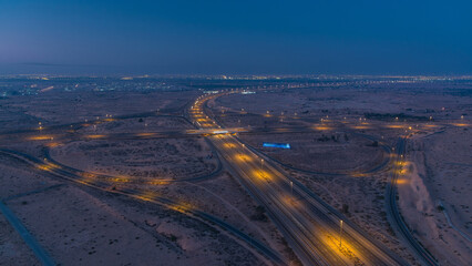Highway roads with traffic night to day timelapse in a big city from Ajman to Dubai before sunrise.