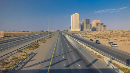 Highway roads with traffic timelapse in a big city from Ajman to Dubai before sunset....