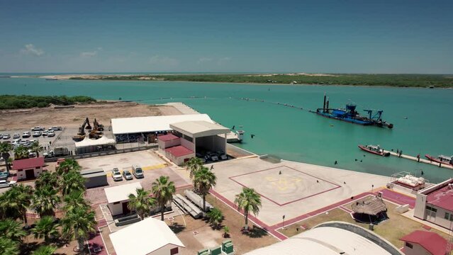 Sand drainage plant overlooking the Gulf of Mexico in Matamoros, with numerous birds flying in front of the image.