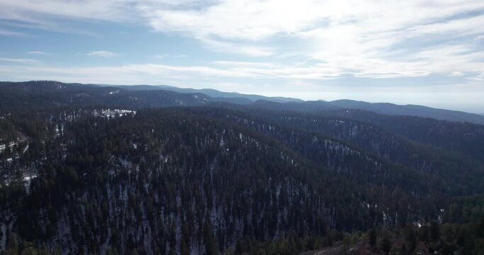 High angle drone shot reveals a snow covered mountain valley in New Mexico