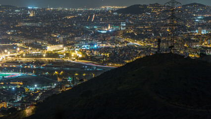 Barcelona and Badalona skyline with roofs of houses and sea on the horizon night timelapse