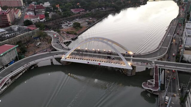 Drone shot of the Binondo Intramuros Bridge spans the Pasig River at sunset in Manila, Philippines