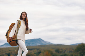 Mountain Adventure: Smiling Woman Enjoying Backpacking on Cliff