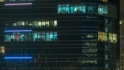 Windows in modern city office building at night timelapse.