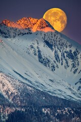 Ogromny księżyc w pełni zachodzi za Tatrami o poranku