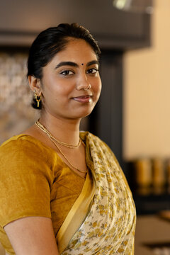 Fototapeta Indian young woman in traditional saree, standing at home