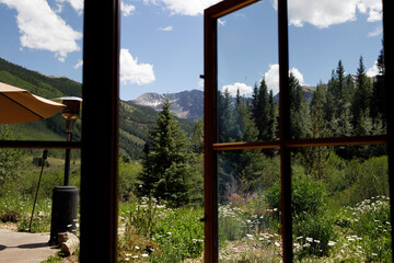 Window view to Colorado's lush landscapes and peaks.