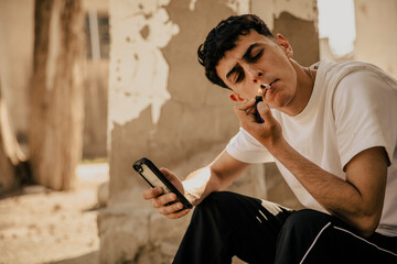 Boy smoking a marijuana cigarette in his neighborhood