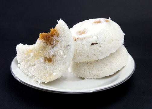 Steamed Rice Cake or Bhapa Pitha is a traditional dish of Bangladesh. Winter rice cake on Black Background. bite or broken pitha. Ingredients are rice powder, molasses, coconut, sugar etc.
