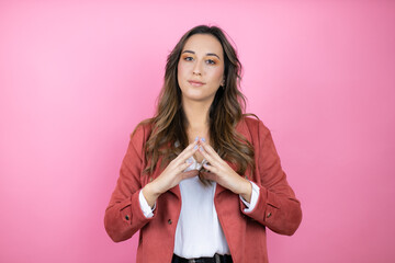Young beautiful woman wearing casual jacket over isolated pink background with Hands together and...