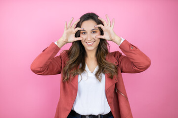 Young beautiful woman wearing casual jacket over isolated pink background Trying to open eyes with...