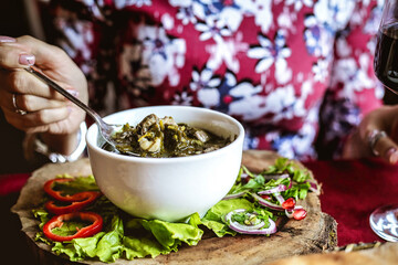 Woman Eating Bowl of Food With Glass of Wine