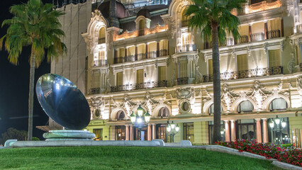 Casino square with palms and fountain at night timelapse in Monte Carlo in Monaco.