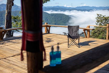 black camping chairs with a view of mist and mountain landscape on a homestay, hill tribe home...