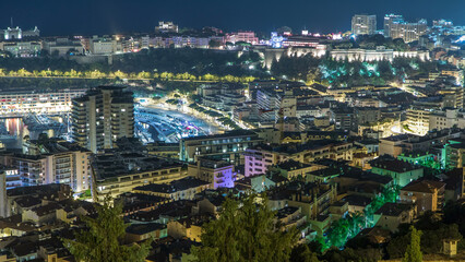 Fototapeta na wymiar Cityscape of Monte Carlo, Monaco night timelapse with roofs of buildings and traffic on roads.