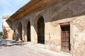 ruins of shalimar gardens old wooden door in a wall  Shalimar Gardens Lahore Pakistan,  beautiful wall carved cusped arches, material used lime stone, brick, white marble , also have a wooden door.
