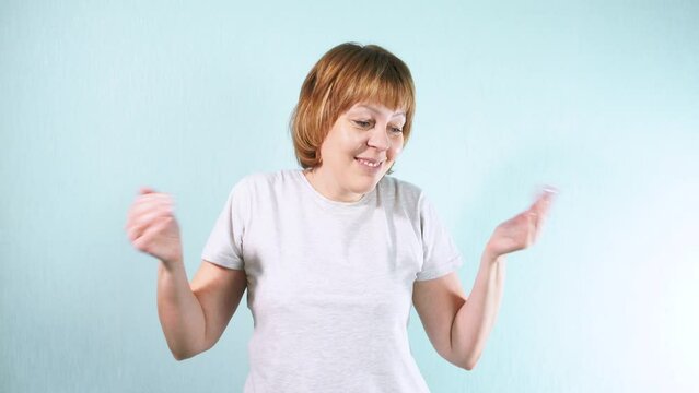 A young woman smiles at the camera, spreading her arms to express acceptance of the situation. Positive concept of adapting to circumstances.