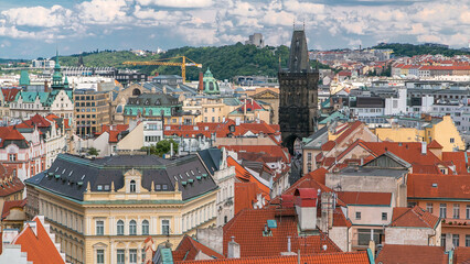 Fototapeta na wymiar Aerial view of the traditional red roofs of the city of Prague, Czech Republic with the Powder tower and Vitkov Hill in the distance timelapse.
