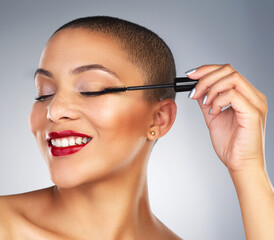 Cosmetics, mascara and portrait of woman with red lips in studio for lipstick and eyelash routine. Makeup, beauty and face of female person with facial cosmetology treatment by gray background.