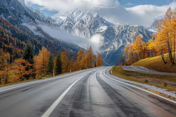 The road curves through a picturesque autumn scene with golden trees and imposing snowy mountains in the backdrop