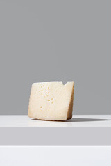 Trozo de queso de oveja curado. Cuña de queso manchego sobre fondo gris	