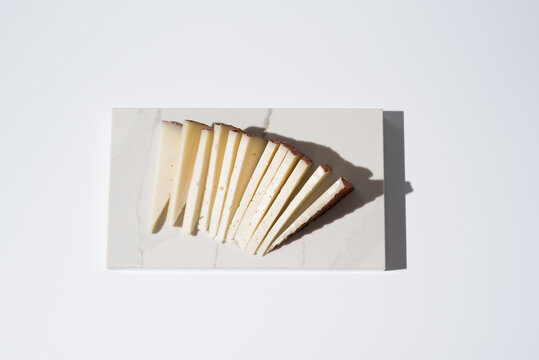 Trozos de queso de cabra curado. Aperitivo español en una placa de mármol. Vista superior