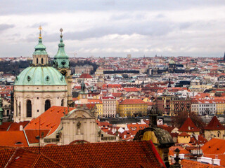 Fototapeta na wymiar Rooftops of the Malá Strana, also known as the Lesser town of Prague, Czech Republic, with the baroque dome of the church of St Nicolas in the foreground