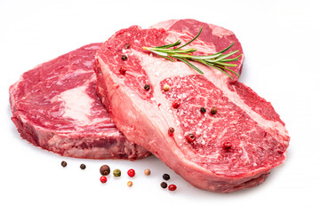 Raw ribeye steaks with pepper corns and rosemary isolated on white background.