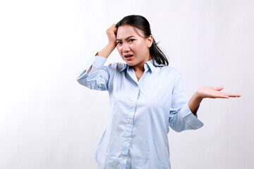 Stressed young attractive asian woman showing confused gesture while holding her head with unhappy...