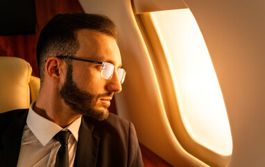 Businessman wearing corporate business suit flying on luxury private jet, concepts about travel,...