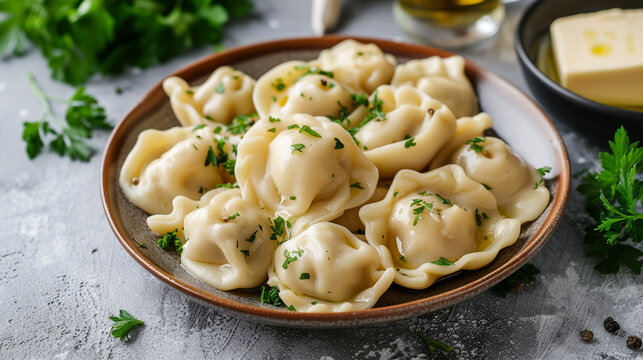 A plate of pelmeni with dumplings filled with minced meat, boiled in water, and topped with butter and parsley.