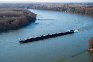 View from the hill on the Danube river in Bratislava. There is a cargo ship on the river. Autumn.