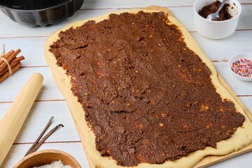 Step -by -step cooking with a twisted yeast roll with a poppy filling. Step the second, smeared poppy filling on a rolled layer of dough.