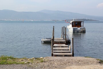 Boat dock with boat on waters of Torasan Bay, Urla Izmir, Turkey