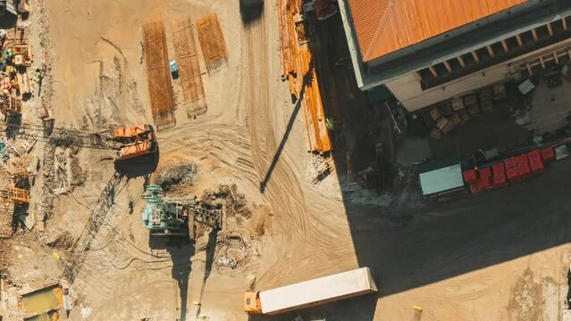 Workers hammer foundation piles. trucks, machinery working in development on construction site. timelapse time lapse Construction And Development Business. Elevated View construction site area.