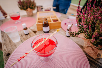 Dobele, Latvia - August 18, 2023 - Candle-making supplies on a table with a pink placemat,...