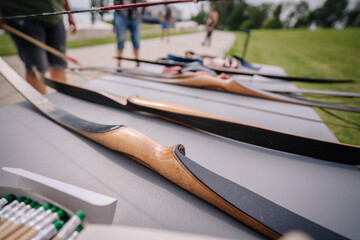 Dobele, Latvia - August 18, 2023 - Close-up of a row of traditional wooden archery bows on a table,...