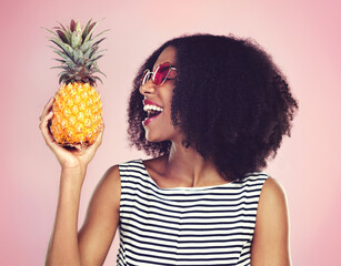 Studio, profile and black woman with pineapple, detox and bite on pink background. Health,...