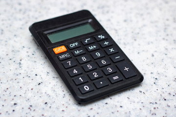 Black calculator on white counter, office equipment, communication device