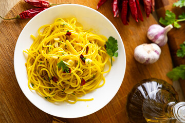 A plate of spaghetti aglio e olio with chili flakes, fresh parsley, garlic, and a drizzle of extra virgin olive oil