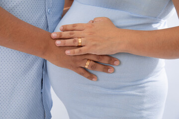 Pregnant human belly being held by hands
