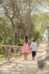 Obraz premium Family members walking together holding hands in a sunny day in a park in Lima Peru